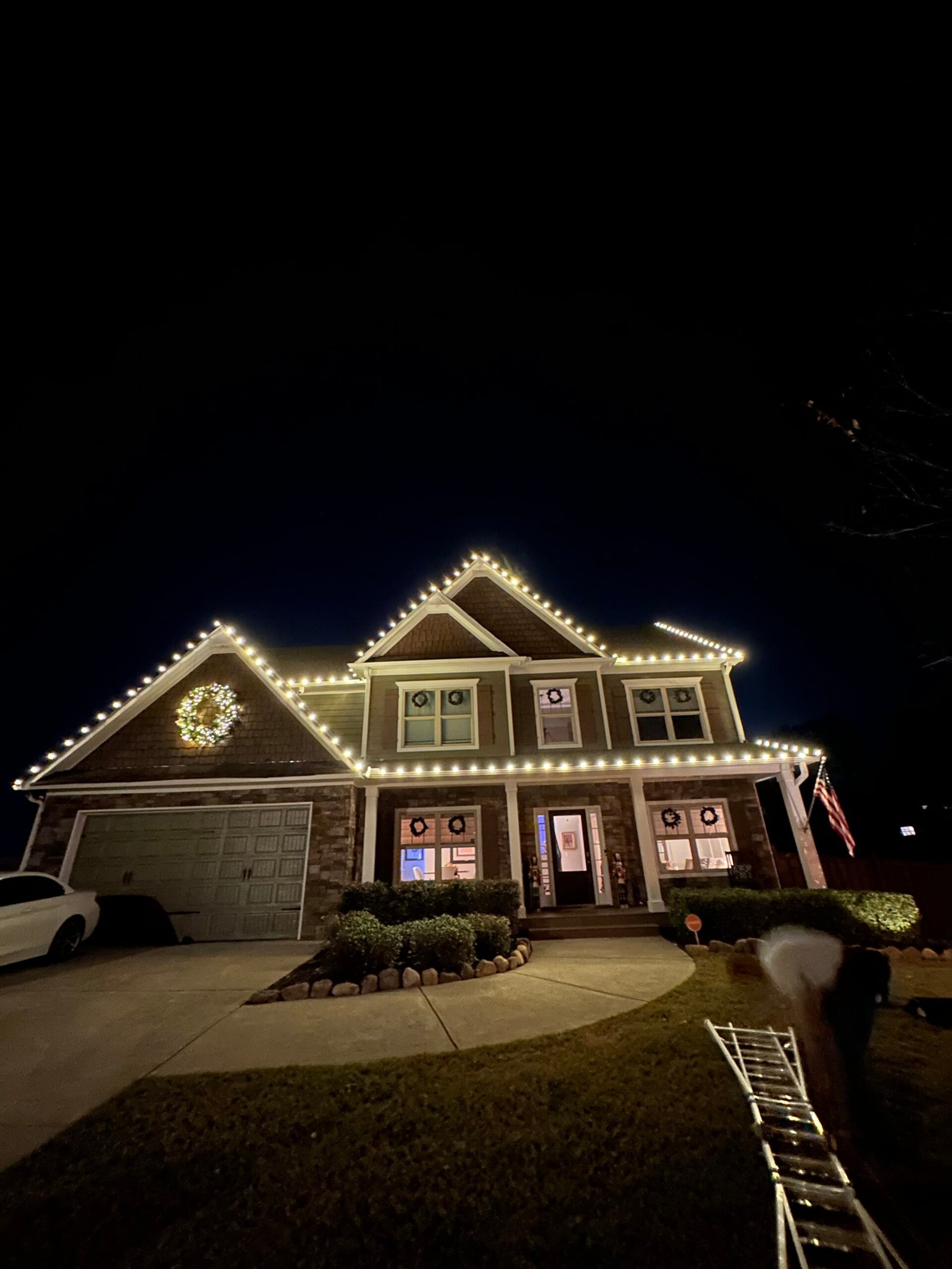 Warm white roofline lighting installed by Red Clay